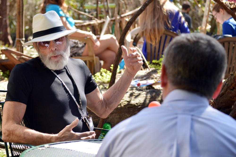 Jon Anderson talks with representatives from UF's physical plant Wednesday. The representatives told Anderson the art installation needs to be removed by Monday.