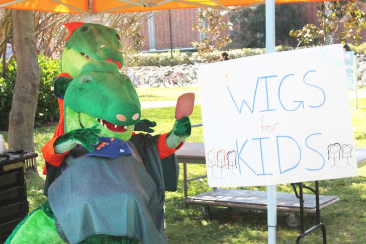 Alberta grooms Albert in the Wigs for Kids station Tuesday at the Friends For Life Chomp Cancer Carnival. The event included a variety of activities that raised awareness for pediatric cancer.