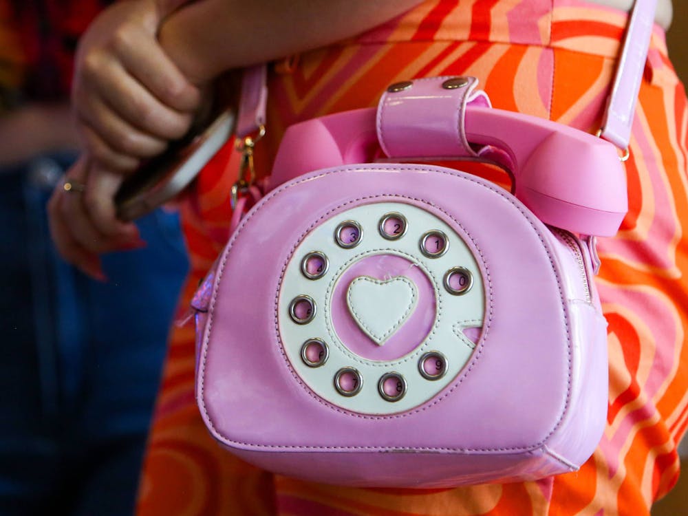 <p>Amber Cabassa flashes her pink rotary dial phone purse at Regal Celebration Pointe on Wednesday, July 19, 2023.</p><p><br/><br/><br/><br/></p>