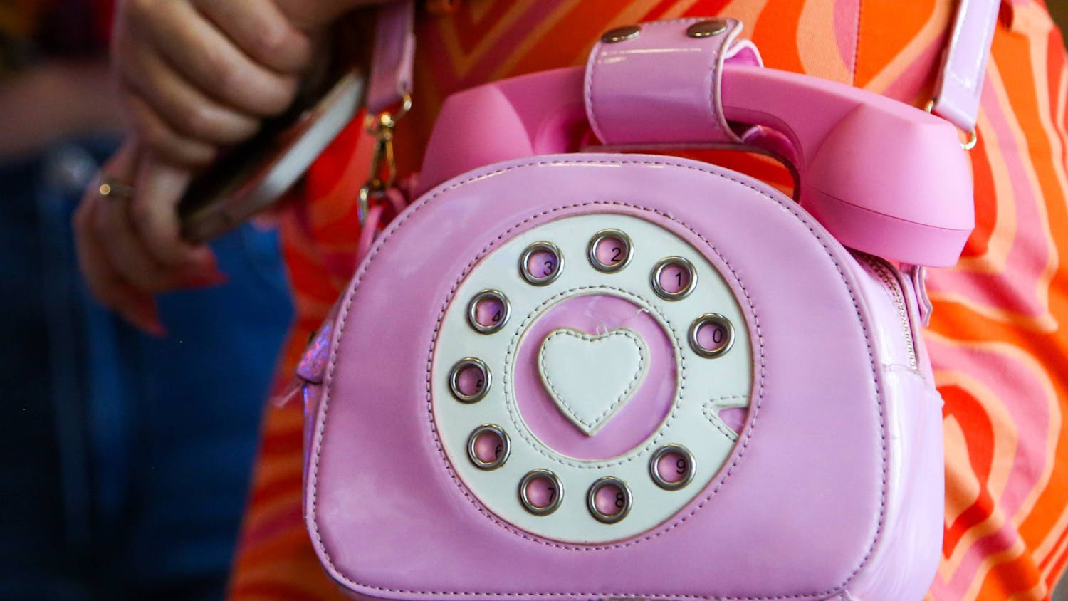 Amber Cabassa flashes her pink rotary dial phone purse at Regal Celebration Pointe on Wednesday, July 19, 2023.