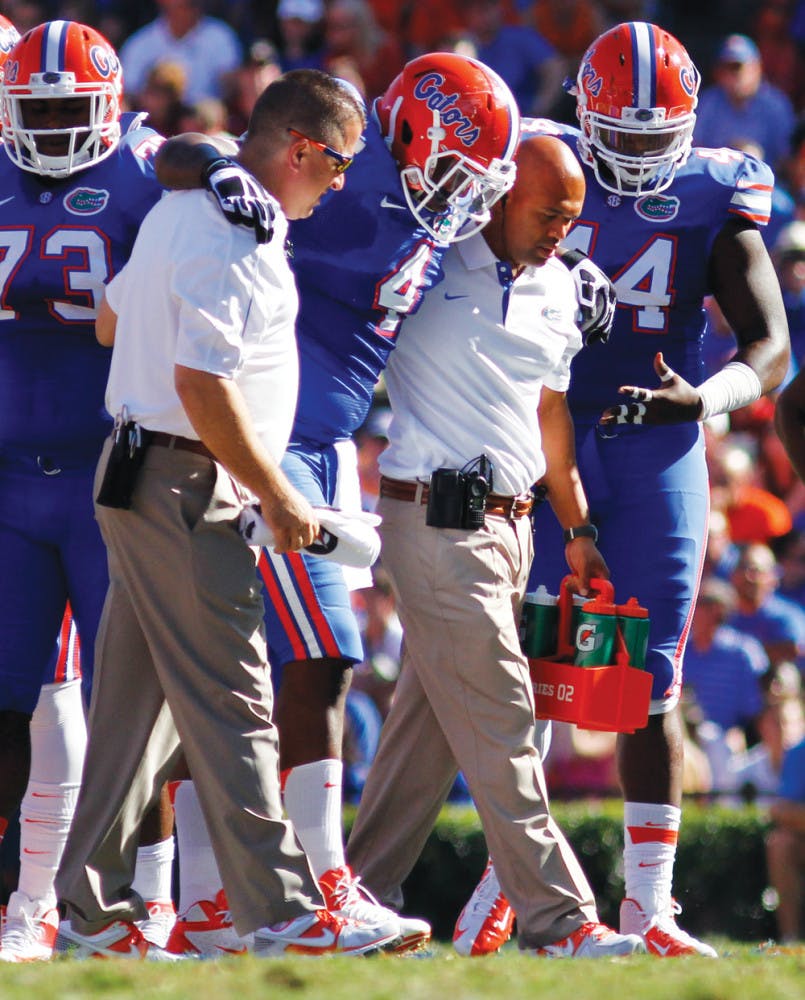 Damien Jacobs (4) gets helped off the field during Florida’s 44-11 win against South Carolina on Saturday in The Swamp. Jacobs is expected to practice today.
