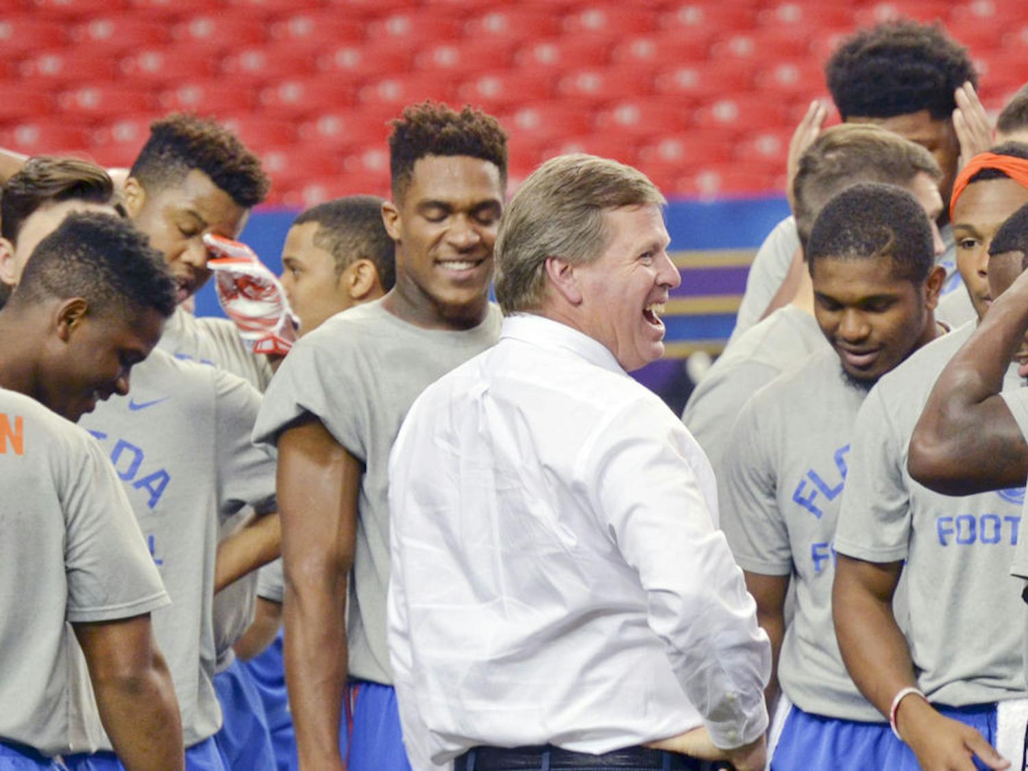 UF coach Jim McElwain laughs with players after practice on Dec. 4, 2015, prior to the SEC Championship Game in Atlanta.