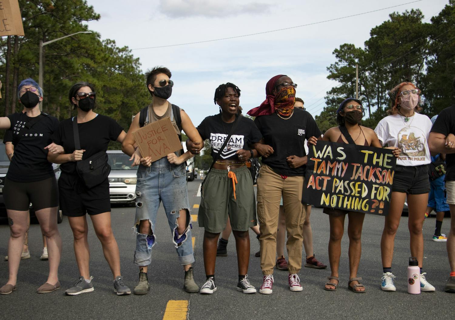 Protestors lock arms to block traffic on Northeast 39th Avenue outside Alachua County Jail on Saturday, Aug. 21, 2021. 