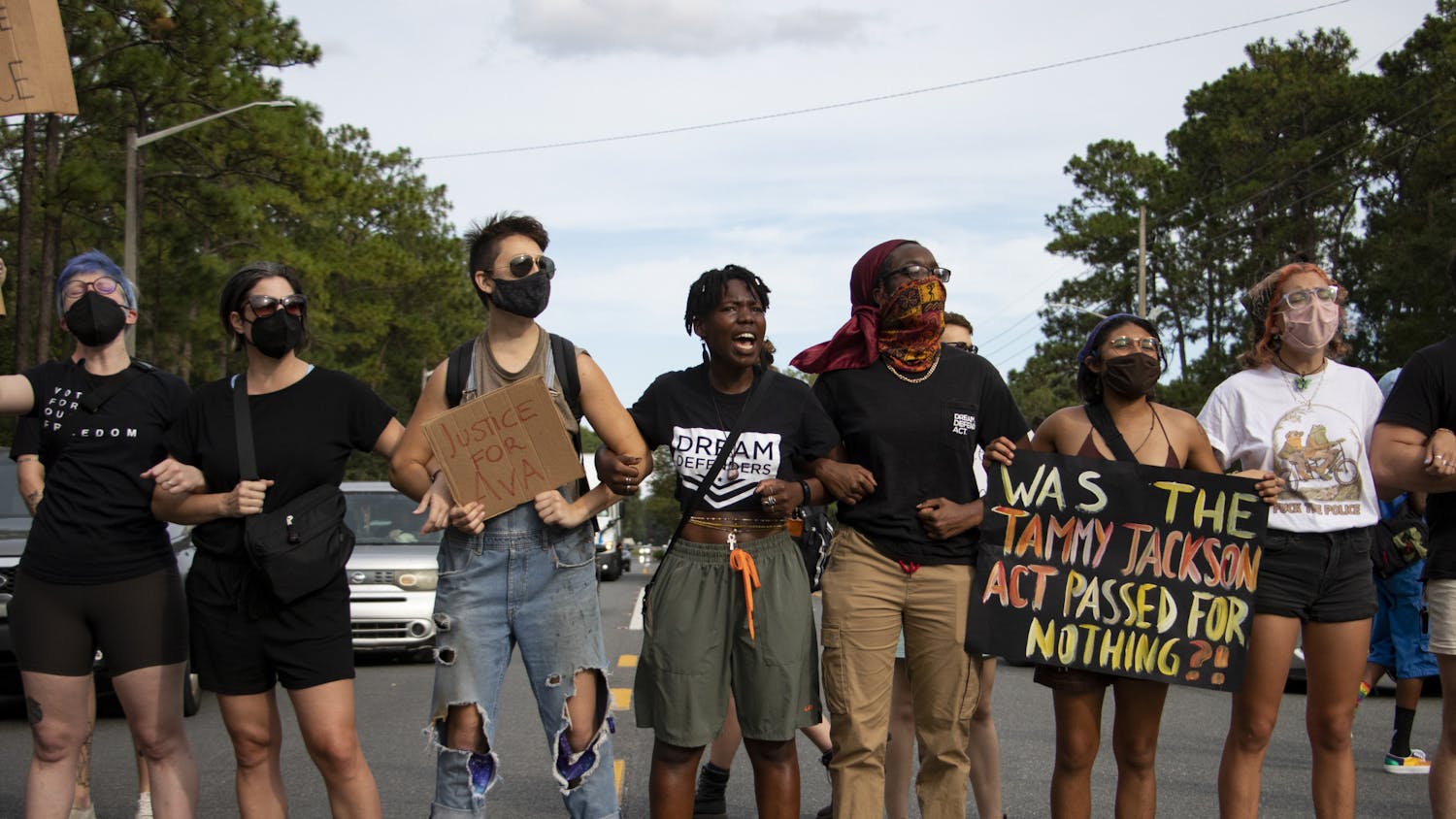 Protestors lock arms to block traffic on Northeast 39th Avenue outside Alachua County Jail on Saturday, Aug. 21, 2021. 