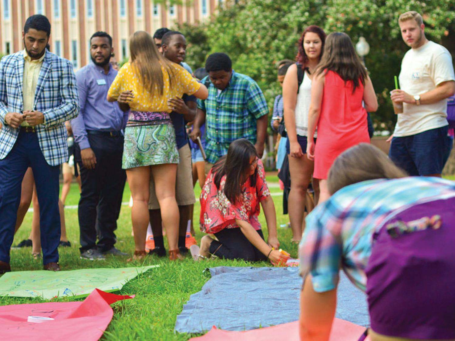 UF students sign banners at the No Gator Walks Alone event on the Plaza of the Americas on Monday evening. No Gators Walks Alone is meant to raise awareness about sexual assault and encourage Gators to look out for one another