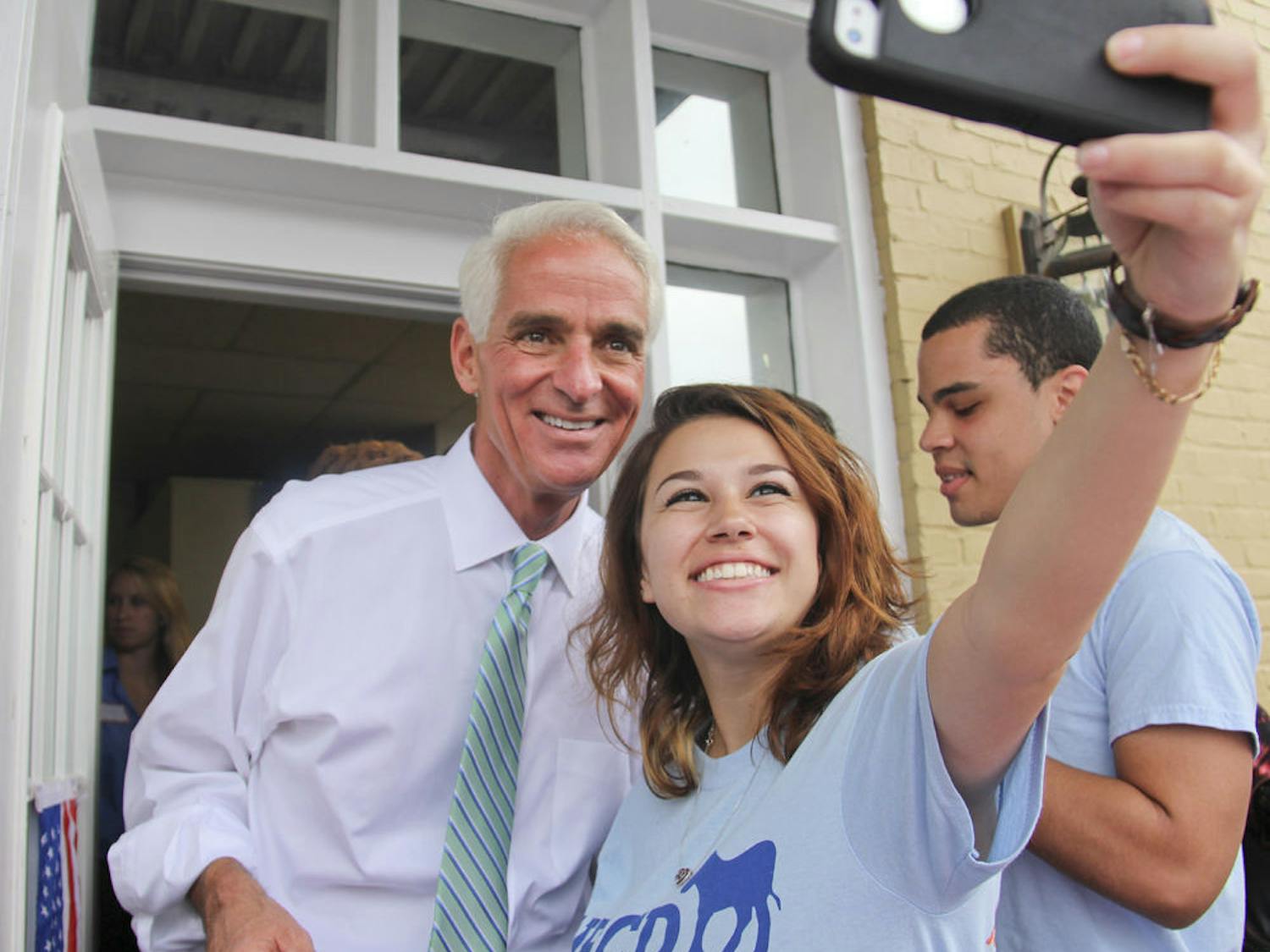 Stefani Dopico, a 19-year-old UF telecommunication sophomore, takes a selfie with Charlie Crist at the Alachua County Office of the State Attorney Sunday afternoon. 