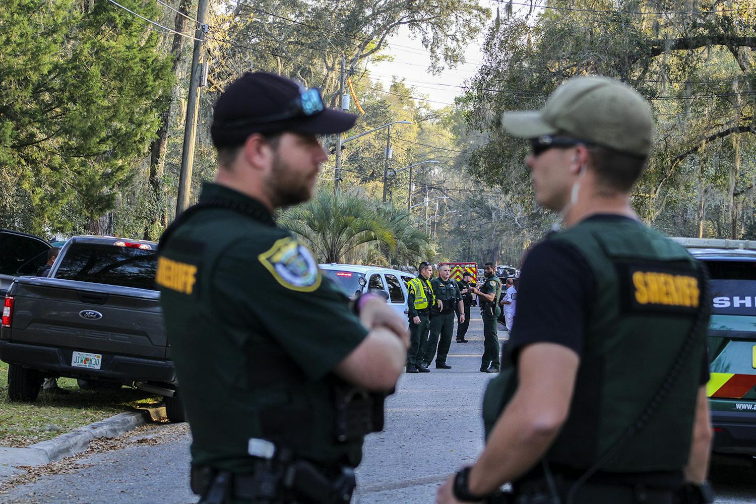 Law enforcement from the Alachua County Sheriff&#x27;s Office stand near crime scene tape on Southeast 46th Terrace on Friday, March 5, 2021, where a person died after a shootout between ACSO deputies and the individual.