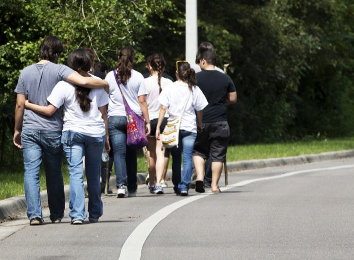 Volunteers searching for Christian Aguilar, who has been missing since Thursday evening, return to their cars after an unsuccessful trek into the woods near Cabana Beach apartments Monday afternoon. Pedro Bravo, who police identified as a person of interest, was arrested Monday afternoon in connection with the disappearance.