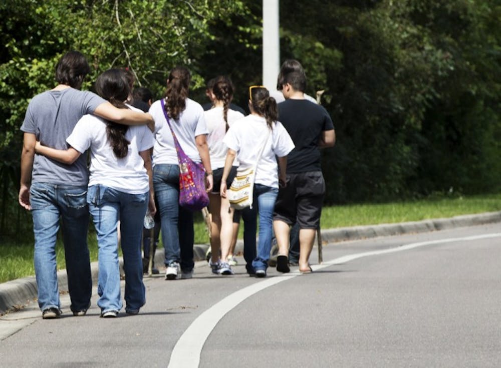 <p>Volunteers searching for Christian Aguilar, who has been missing since Thursday evening, return to their cars after an unsuccessful trek into the woods near Cabana Beach apartments Monday afternoon. Pedro Bravo, who police identified as a person of interest, was arrested Monday afternoon in connection with the disappearance.</p>