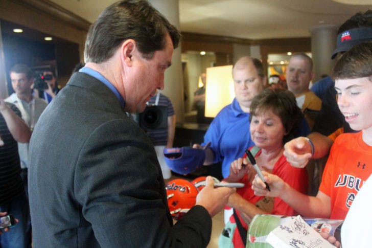 UF coach Will Muschamp signs autographs during the Southeastern Conference Media Days in Hoover, Ala.