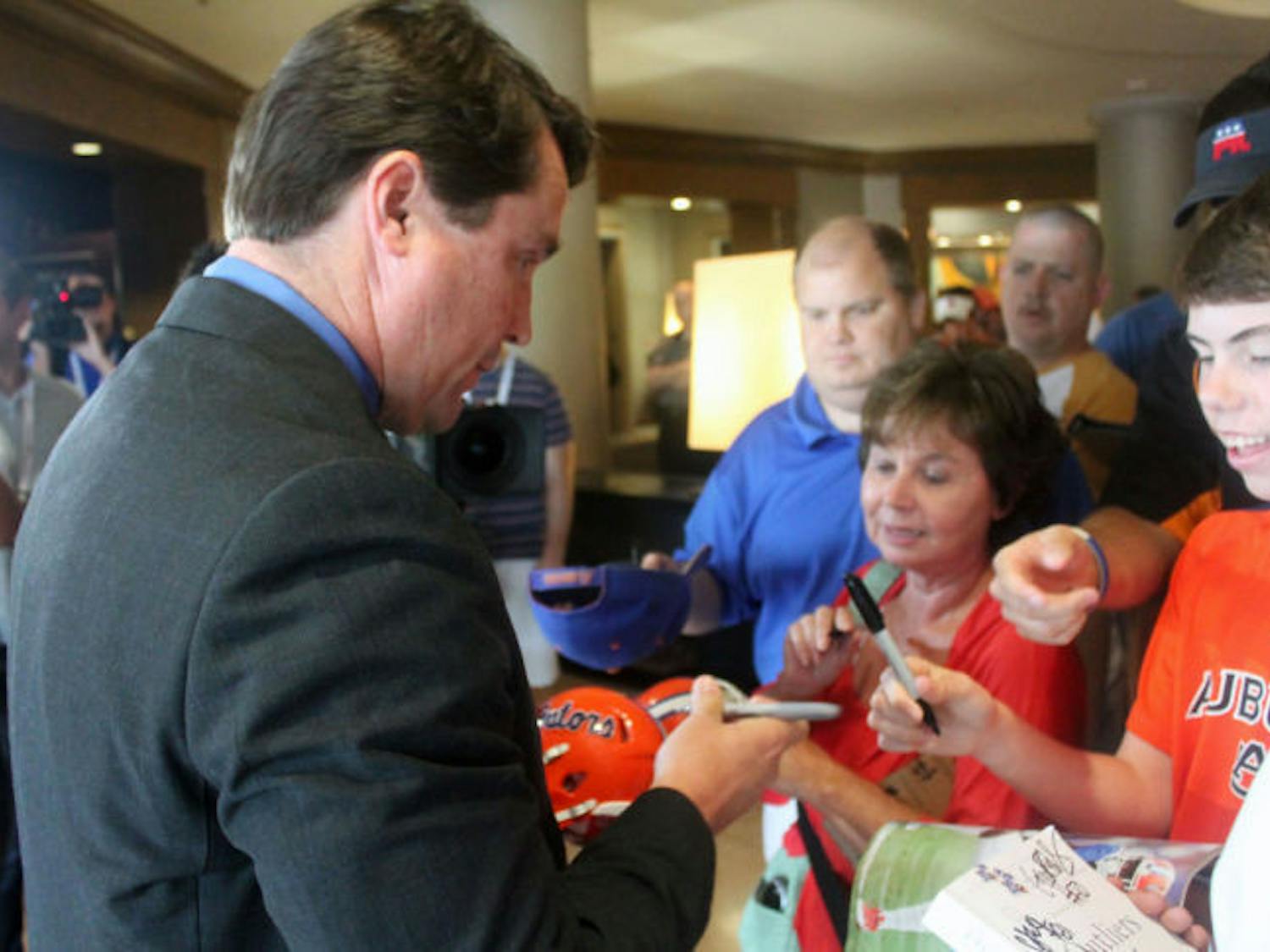 UF coach Will Muschamp signs autographs during the Southeastern Conference Media Days in Hoover, Ala.