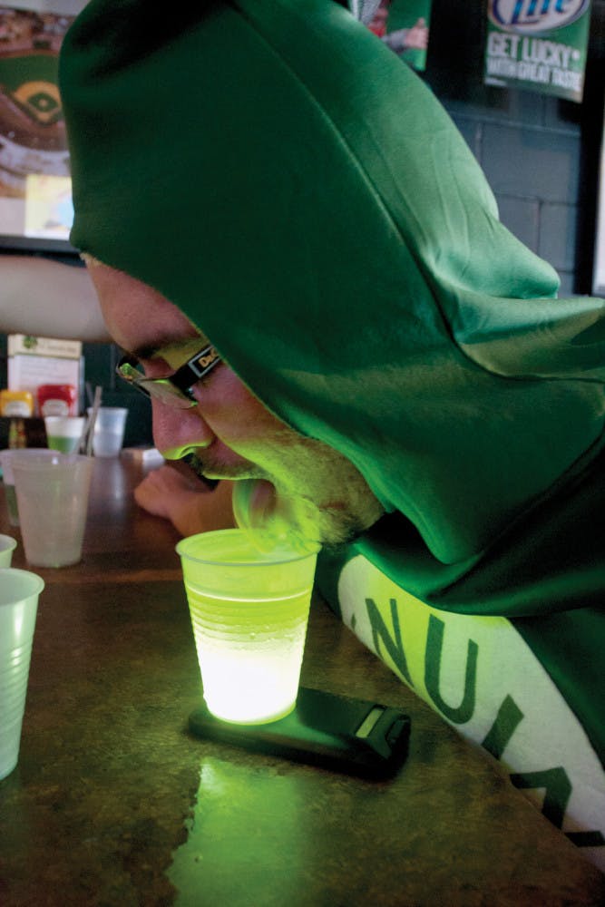 Dressed as a can of beer, David Martinez, 24, finds an alternate way to drink the green beer served at Mother's Pub &amp; Grill on Saturday morning.