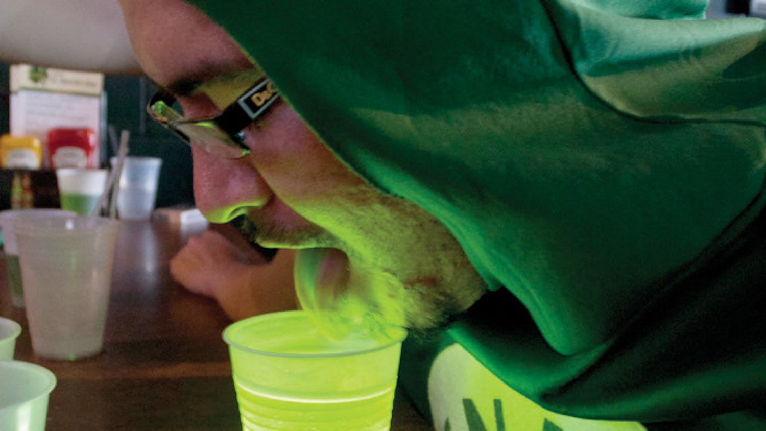 Dressed as a can of beer, David Martinez, 24, finds an alternate way to drink the green beer served at Mother's Pub &amp; Grill on Saturday morning.