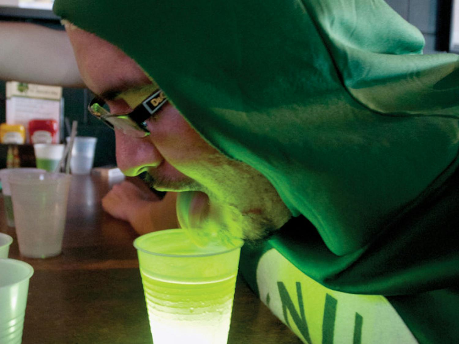 Dressed as a can of beer, David Martinez, 24, finds an alternate way to drink the green beer served at Mother's Pub & Grill on Saturday morning.