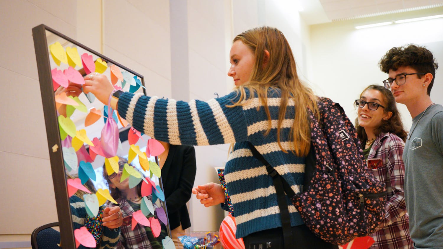 Brooke Dinicola places a sticky note with a body-positive message on a mirror at Sex in the Swamp, an event held at the Reitz Union to promote safe sex practices among college students, Tuesday, March 28, 2023.
