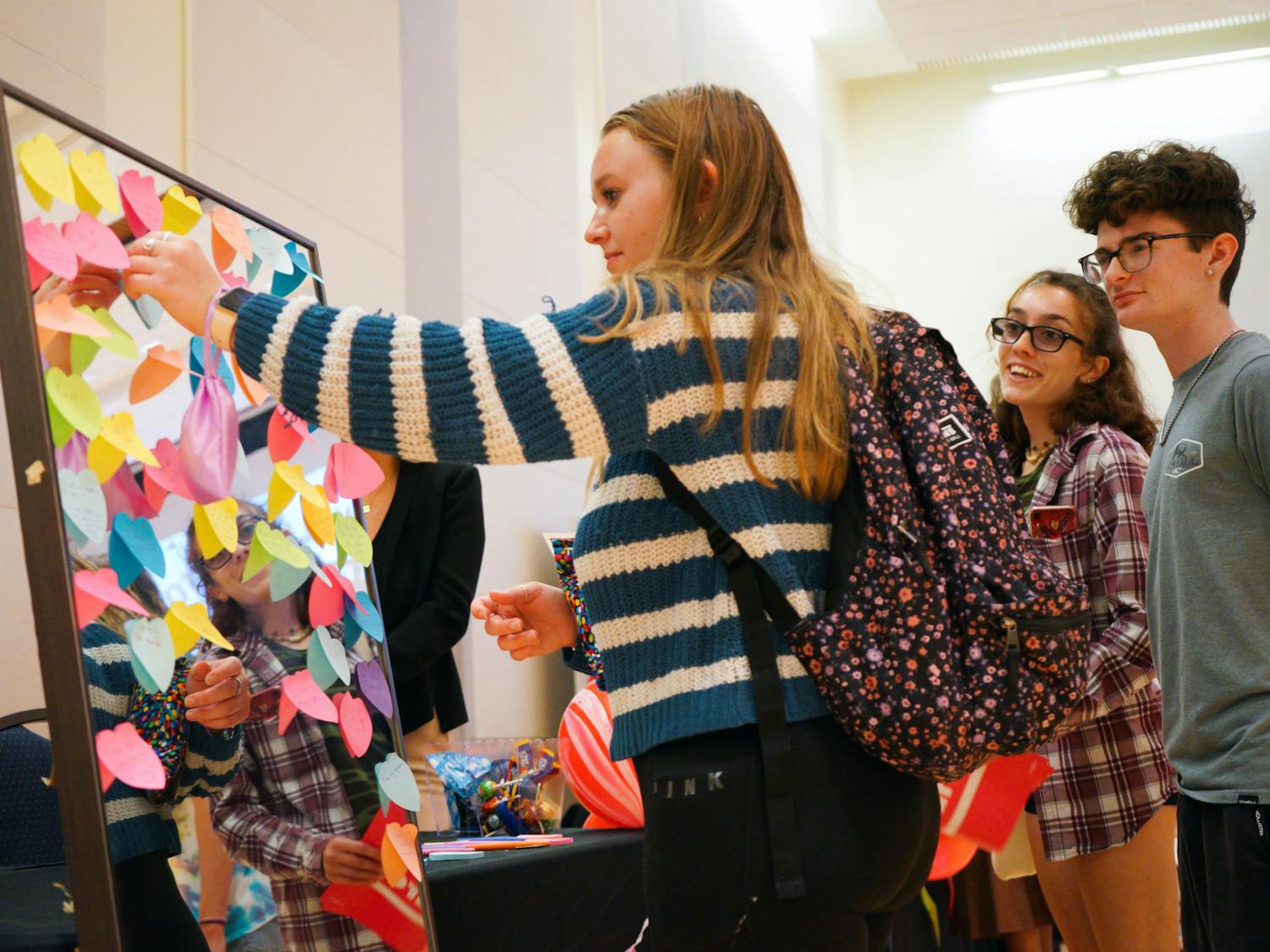 Brooke Dinicola places a sticky note with a body-positive message on a mirror at Sex in the Swamp, an event held at the Reitz Union to promote safe sex practices among college students, Tuesday, March 28, 2023.