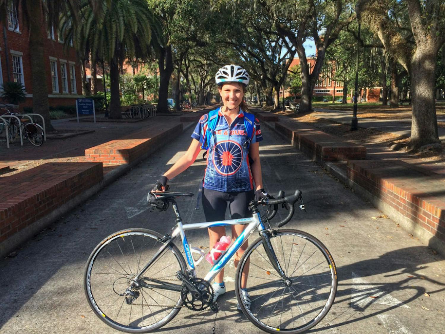 Amanda Brown, a 26-year-old Alachua Elementary School teacher, poses with her road bike on the Plaza of the Americas. The affordable housing advocator will ride 3,963 miles from Portland, Maine, to Santa Barbara, California, with the nonprofit Bike and Build.