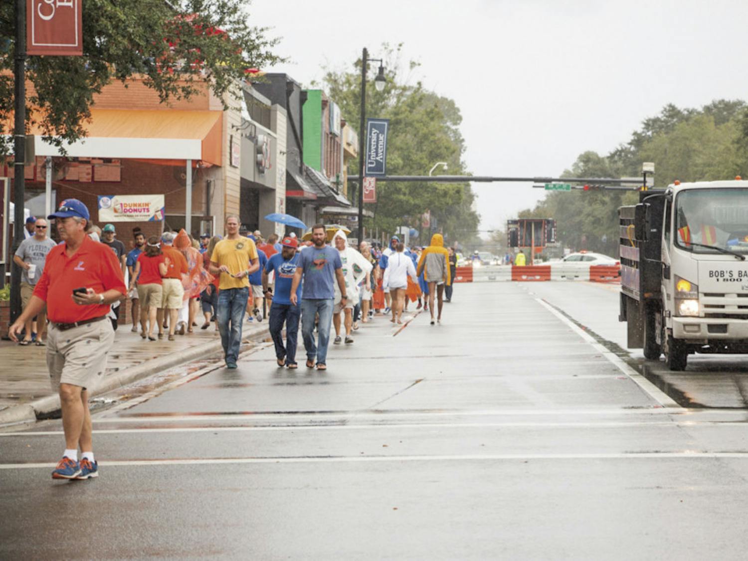Despite the rain, fans walk down the closed-off University Avenue to Ben Hill Griffin Stadium on Saturday afternoon for the UF Homecoming football game.