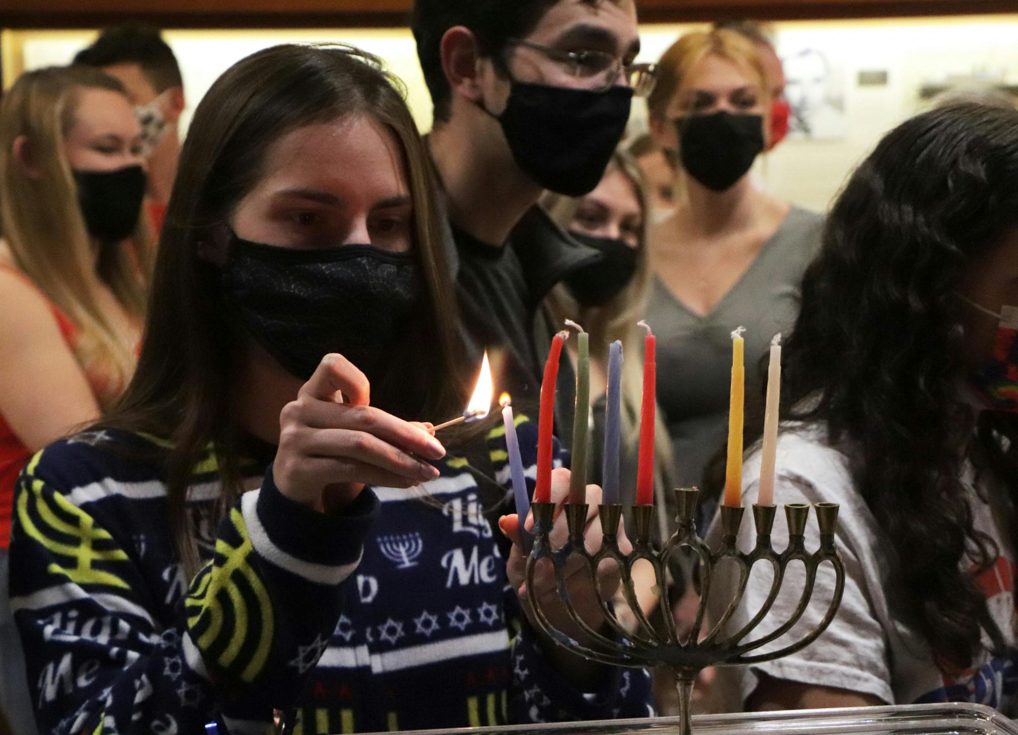 Alex Nelson, UF freshman, lights a menorah for the sixth night of Hanukkah at the UF Hillel’s pajama-themed Shabbat dinner on Friday, Dec. 3, 2021.

