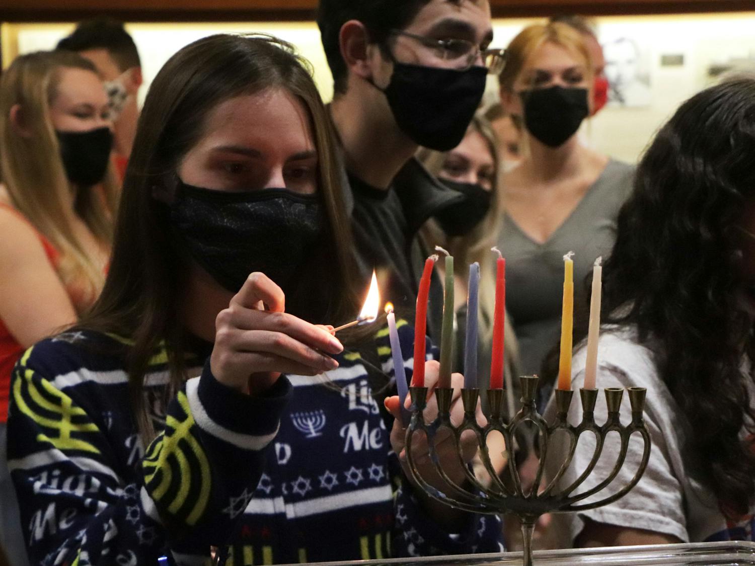 Alex Nelson, UF freshman, lights a menorah for the sixth night of Hanukkah at the UF Hillel’s pajama-themed Shabbat dinner on Friday, Dec. 3, 2021.
