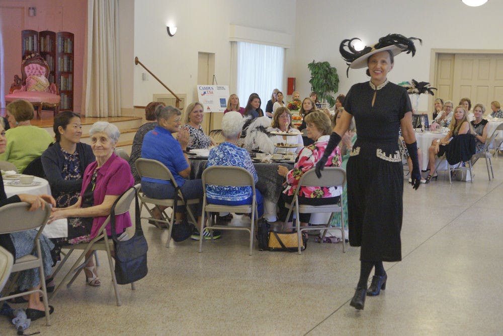 <p>Linda Fuchs, UF President Kent Fuchs' wife, walks down the runway in era clothing during a time period fashion show at the Gainesville Woman’s Club Sept. 10, 2015. The event raised money for the Climb for Cancer Foundation and the oncofertility program at UF.</p>