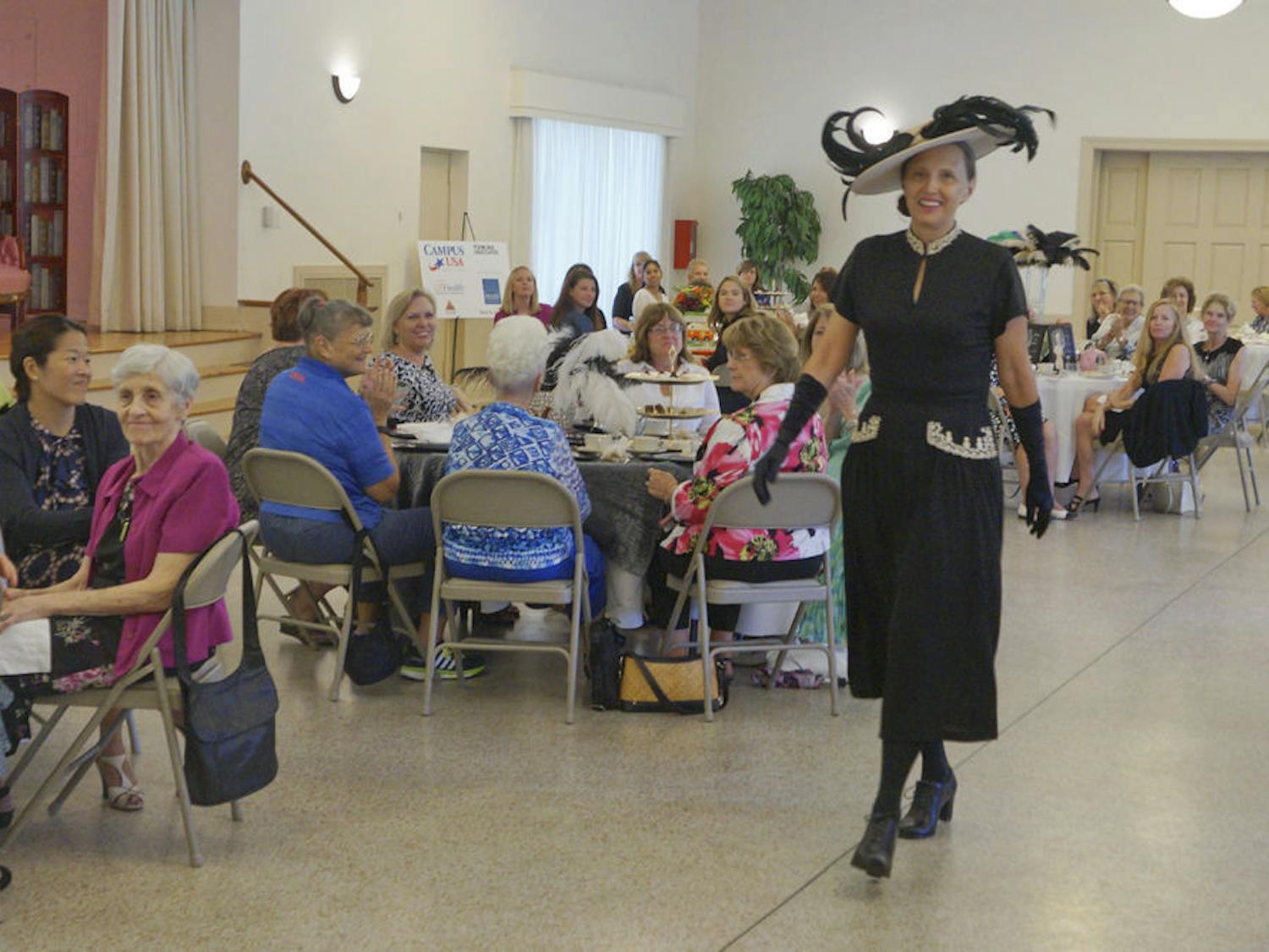 Linda Fuchs, UF President Kent Fuchs' wife, walks down the runway in era clothing during a time period fashion show at the Gainesville Woman’s Club Sept. 10, 2015. The event raised money for the Climb for Cancer Foundation and the oncofertility program at UF.