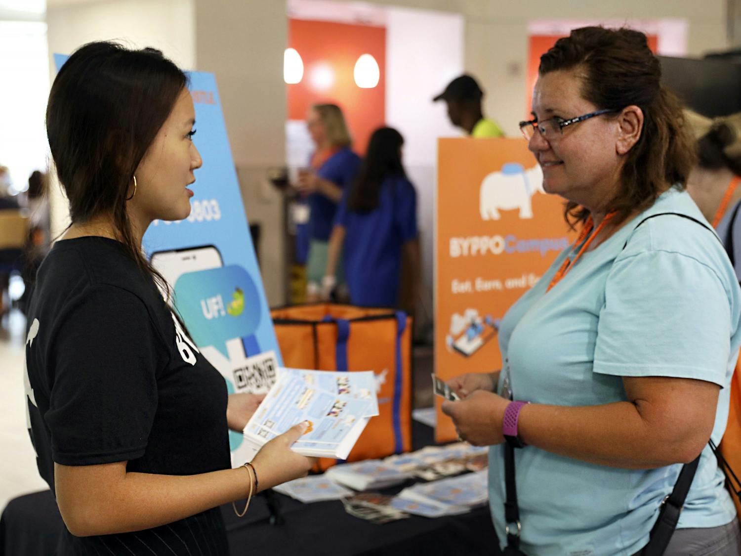 BYPPOCAMPUS founder and CEO Victoria Liu, (left) a UF accounting alumna, introduces her food delivery business to Stephanie Landini, (right) a parent of a UF student, at Gator Dining Center in Gainesville on Friday, July 9, 2021.