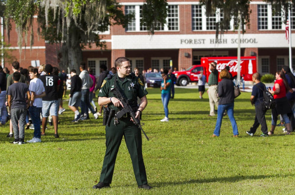 <p>A Marion County Sheriff's Deputy stands outside Forest High School as students exit the school after a school shooting occurred, Friday, April 20, 2018 in Ocala, Fla. One student shot another in the ankle at the high school and a suspect is in custody, authorities said Friday. The injured student was taken to a local hospital for treatment. (</p>