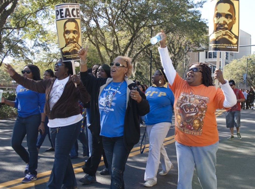<p>Marchers celebrate the life and work of Martin Luther King Jr. at the annual King Celebration Commemorative March on Monday afternoon in Bo Diddley Community Plaza.</p>