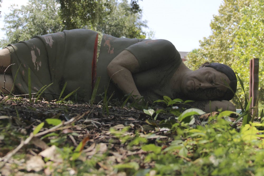 Outside of the College of Architecture, a UF alumna's master thesis project lies in the shade under a tree. The statue, created by Charity White, was designed to create a dialogue about homelessness in Gainesville. The statue disappeared last week. 