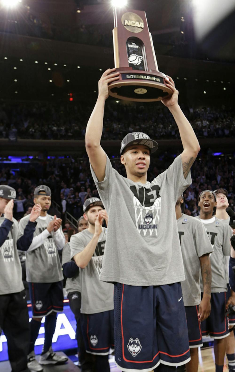<p>UConn guard Shabazz Napier hoists the East Regional trophy after his team’s 60-54 win against Michigan State on Sunday in New York.</p>