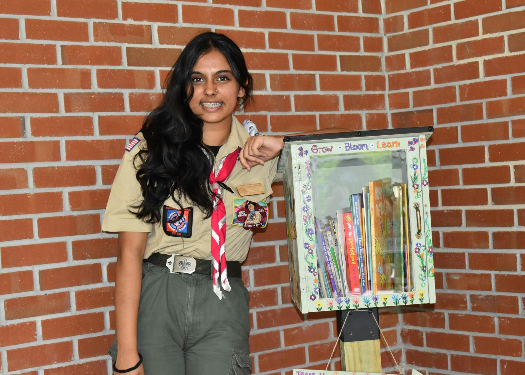 Eagle Scout, Kaayana Sharma, stands next to her lending library service project, Thursday, July 30, 2026 at the UF Early Childhood Collaboratory, in Gainesville, Fla.