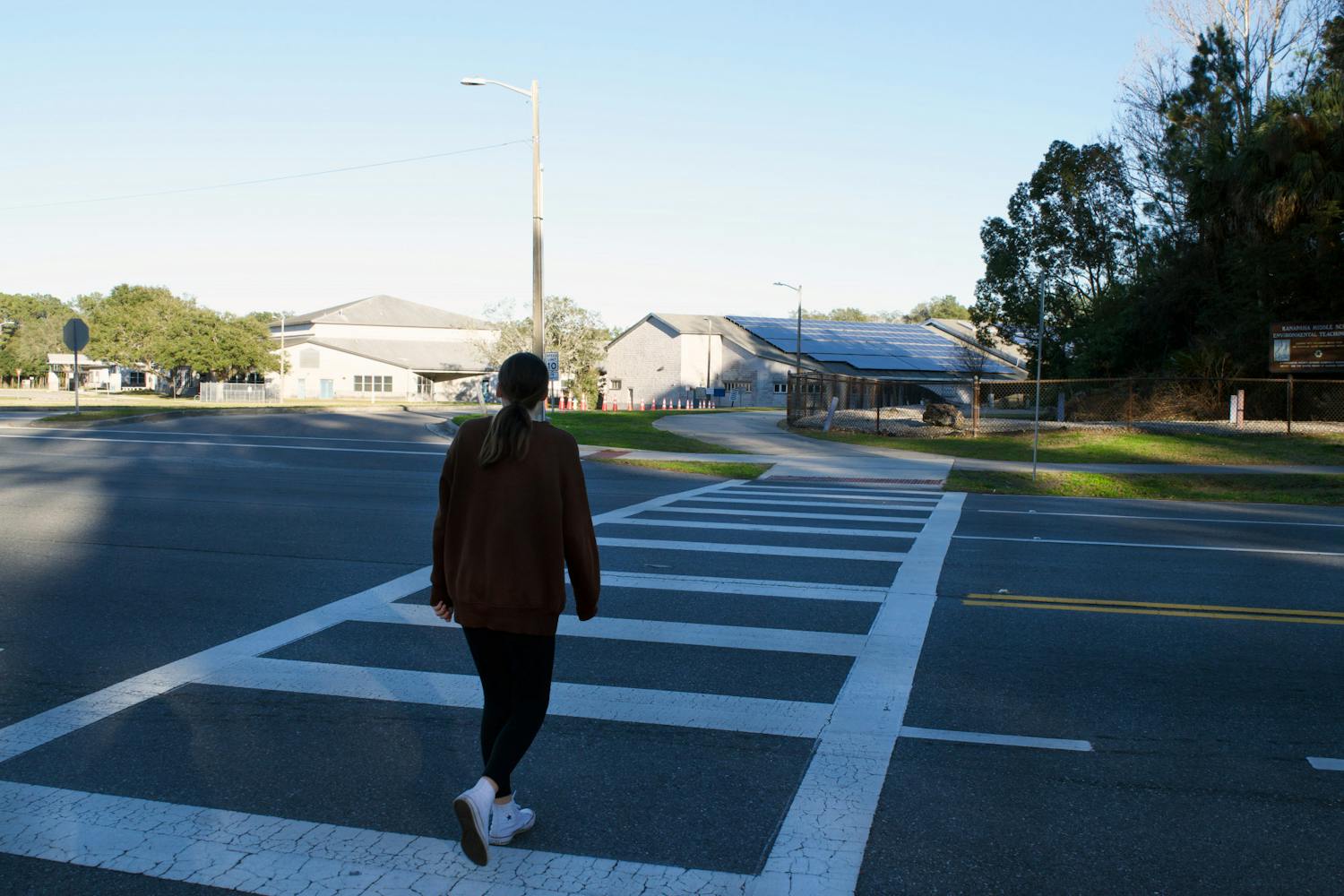 Kanapaha student crosses a sidewalk at the intersection of Tower Road and the entrance of Kanapaha Middle School Saturday, Jan. 14, 2023.