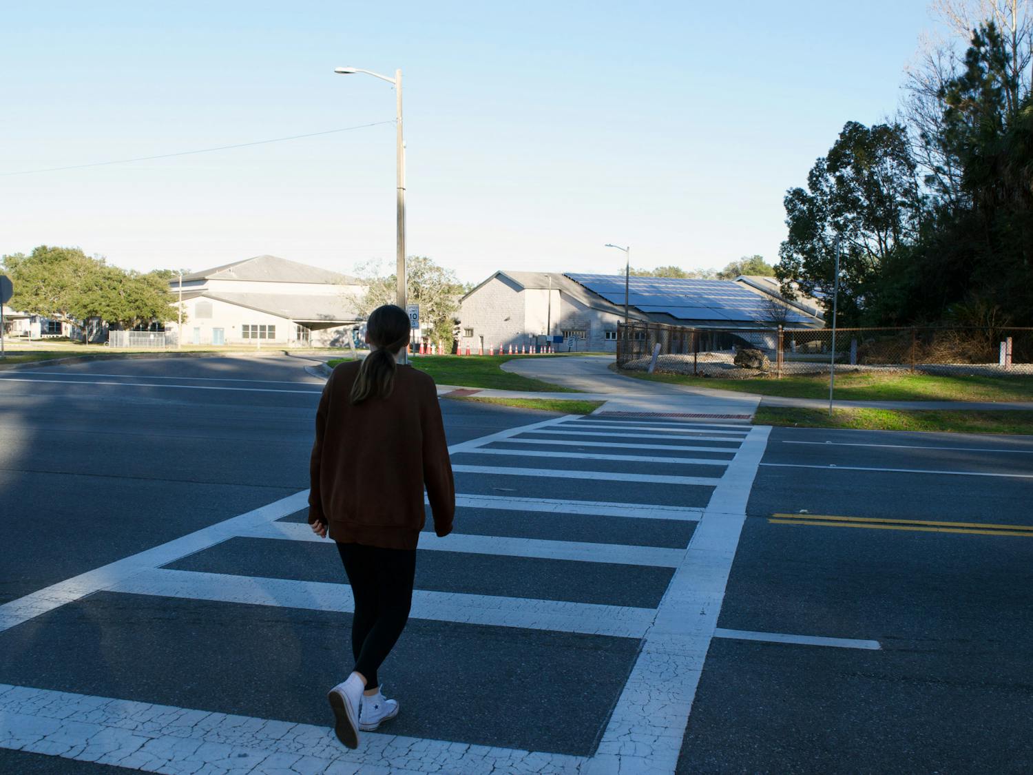 Kanapaha student crosses a sidewalk at the intersection of Tower Road and the entrance of Kanapaha Middle School Saturday, Jan. 14, 2023.