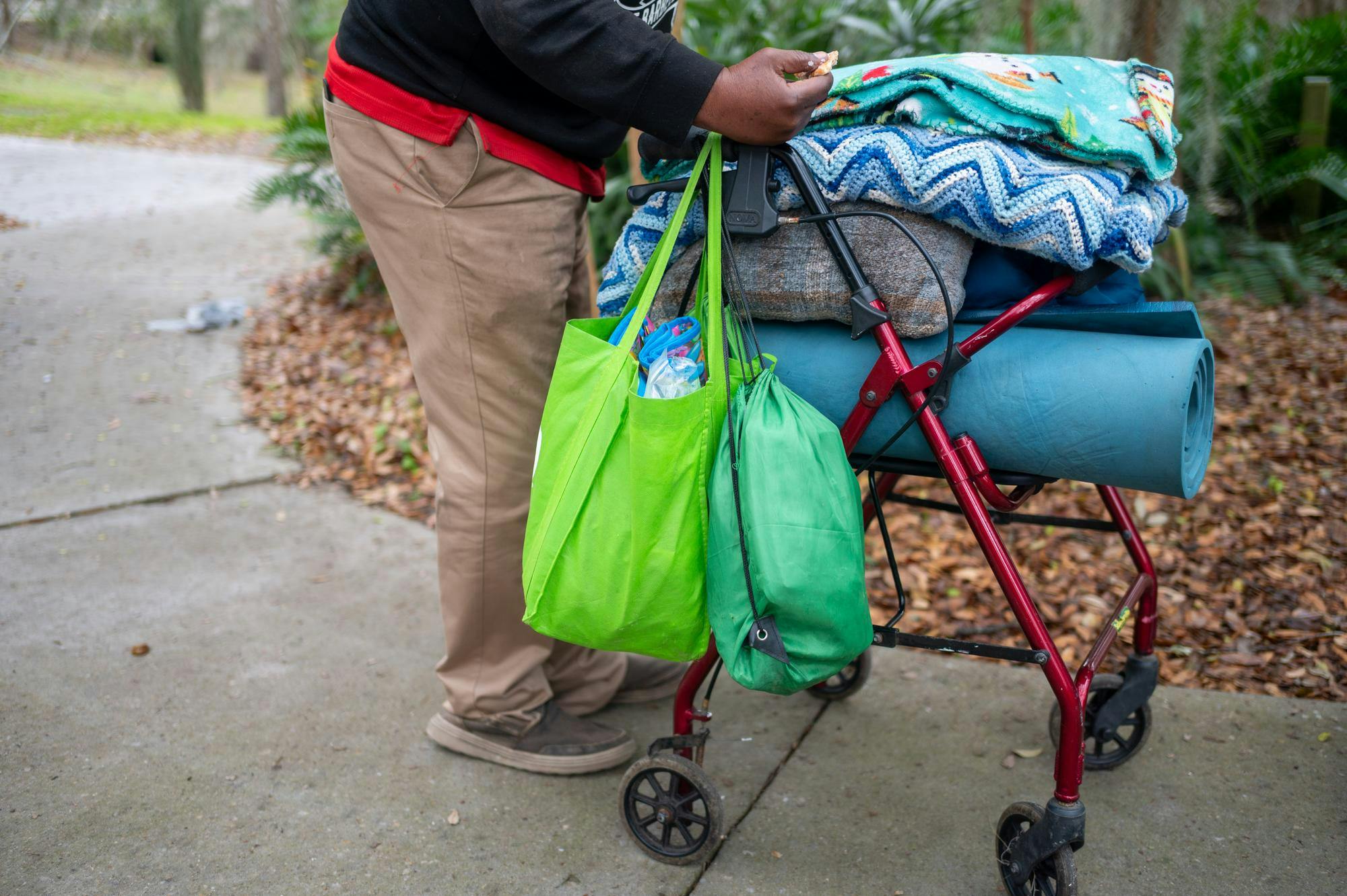 Cyrus Jay wheels his walker and belongings through Sweetwater Park, Saturday, Feb. 28, 2026, in Gainesville, Fla.