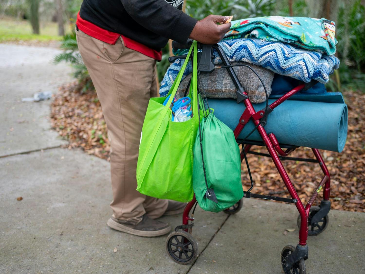 Cyrus Jay wheels his walker and belongings through Sweetwater Park, Saturday, Feb. 28, 2026, in Gainesville, Fla.