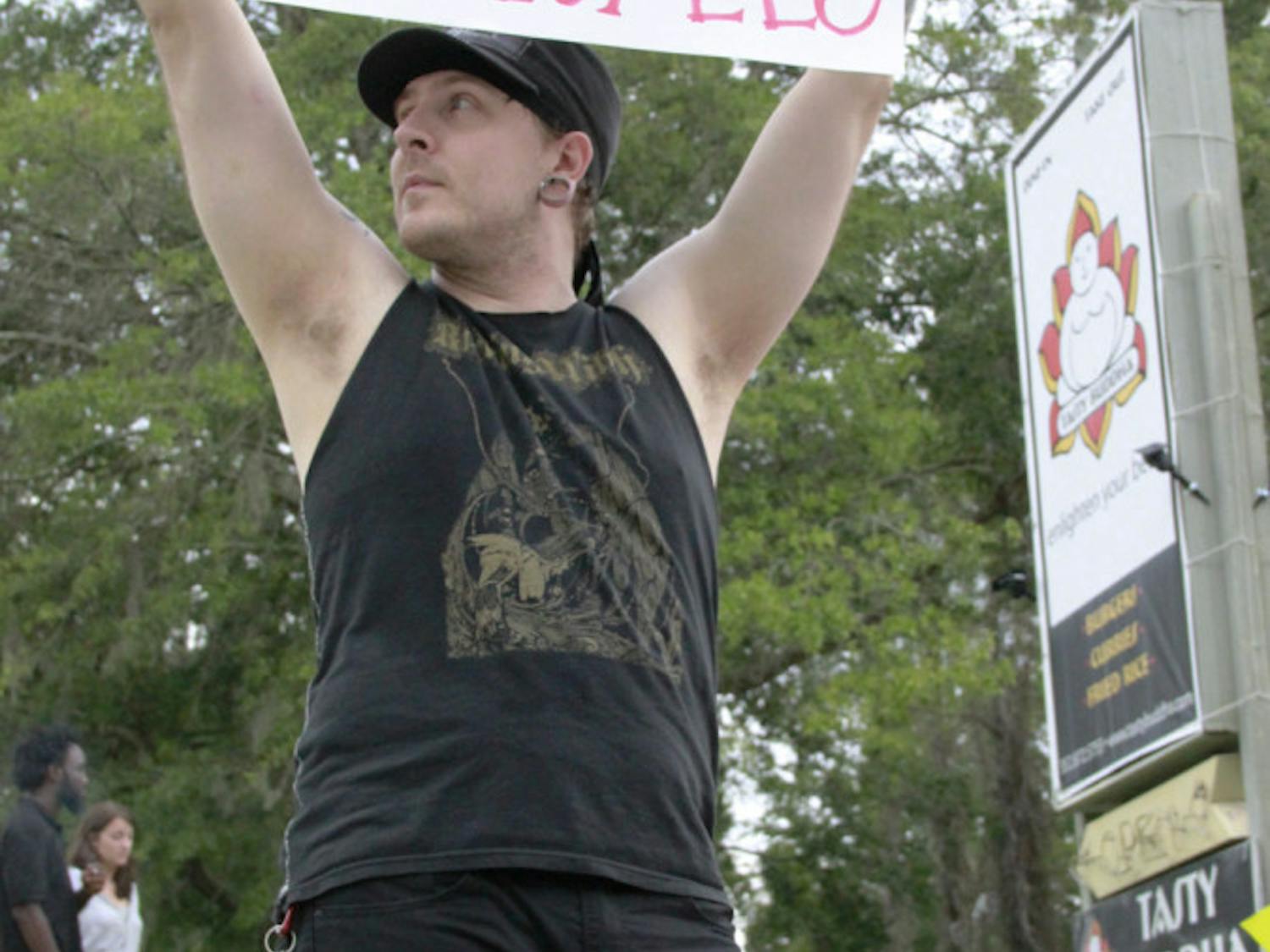 Striking Tasty Buddha cook Dustin Horn protests outside the restaurant Saturday. Employees say there has been a history of bounced checks.