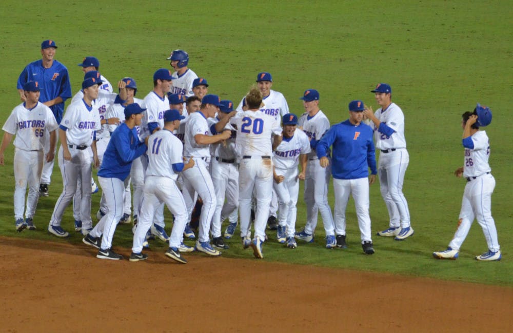 The Florida Gators celebrate with Peter Alonso (20) after he hit a walk-off single in the 10th inning to seal Florida's 4-3 win against Missouri on March 16, 2016, at McKethan Stadium.