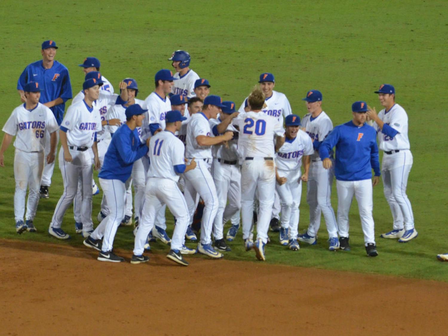 The Florida Gators celebrate with Peter Alonso (20) after he hit a walk-off single in the 10th inning to seal Florida's 4-3 win against Missouri on March 16, 2016, at McKethan Stadium.