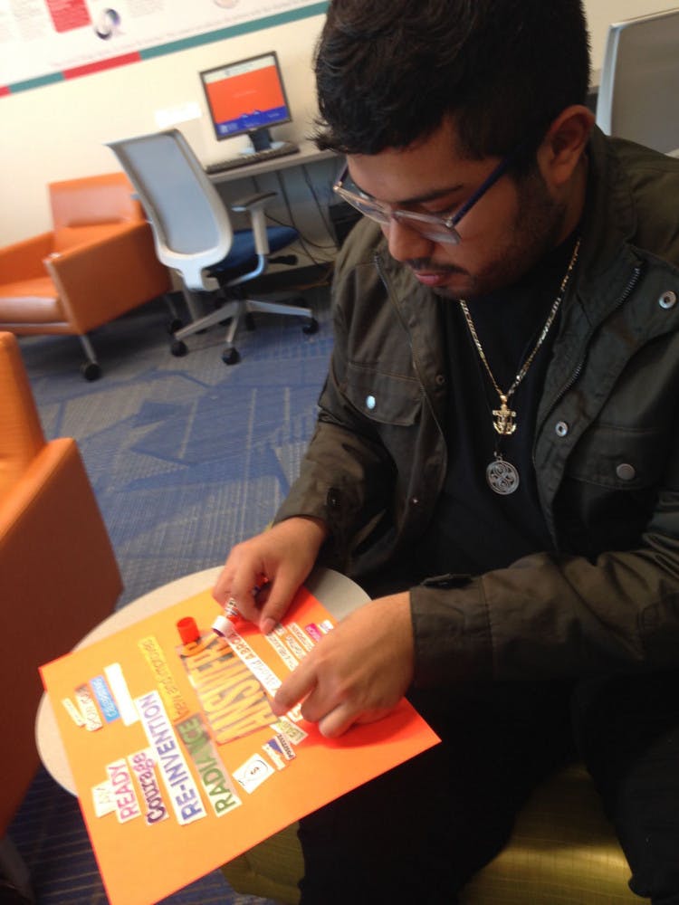 Cristian Laureano, a 20-year-old UF criminology senior, pastes cut-out magazine headlines onto a collage representing his New Year’s resolution to improve all aspects of his life. Laureano was participating in Multicultural and Diversity Affairs “Decolonizing New Year’s Resolutions” event on Monday from 2 p.m. to 4 p.m.
&nbsp;