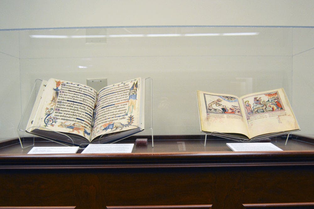 <p>Two examples of the books on display. Left is “The Luttrell Psalter: a facsimile,” a 14th-century illuminated collection of Psalms and other devotional materials; right is “The Cloisters Apocalypse,” an illustrated 14th-century version of the Revelation of St. John.</p>