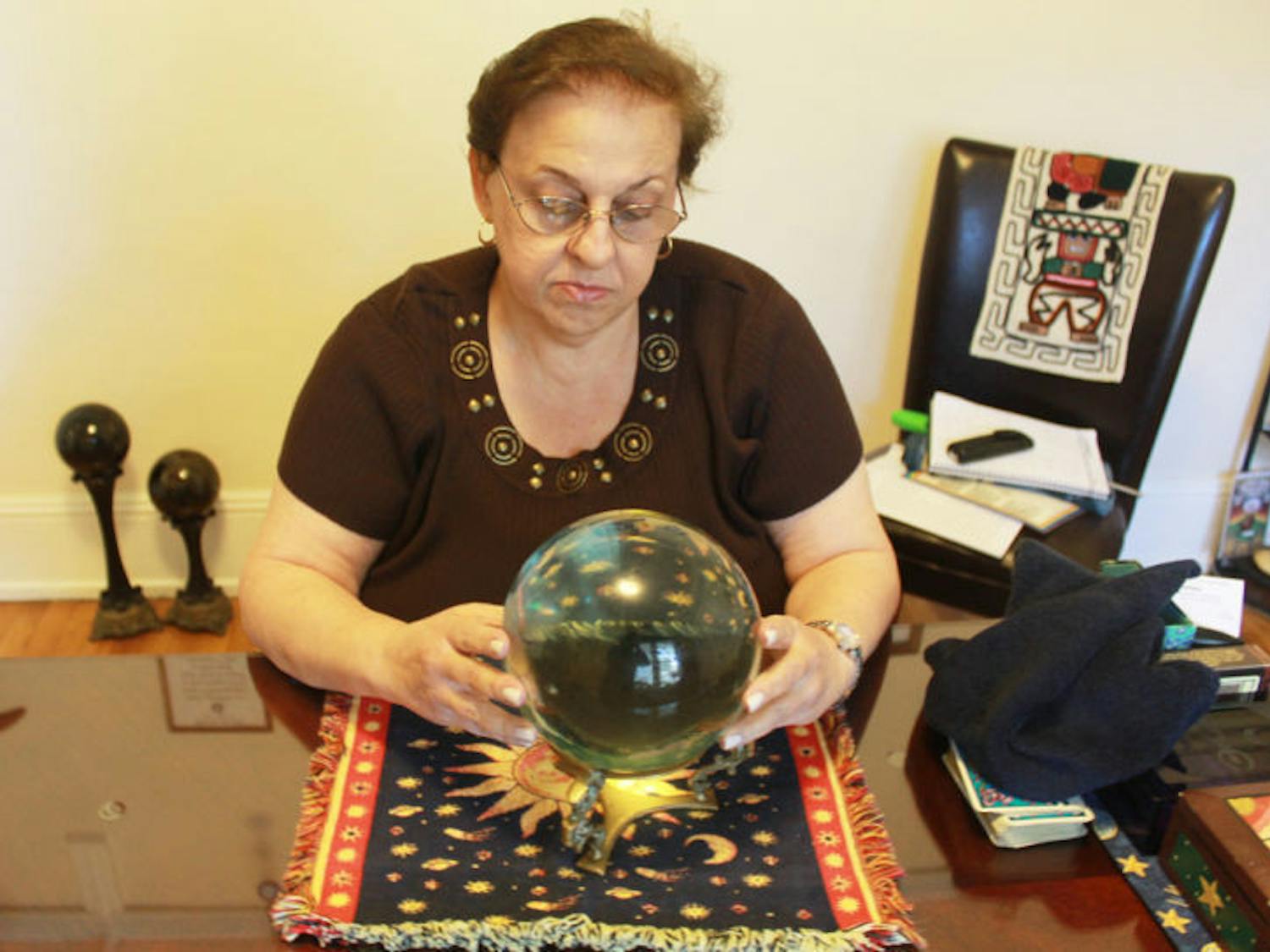 Adviser and psychic reader Theresa Mitchell looks into a crystal ball in her home at 834 E. University Ave.