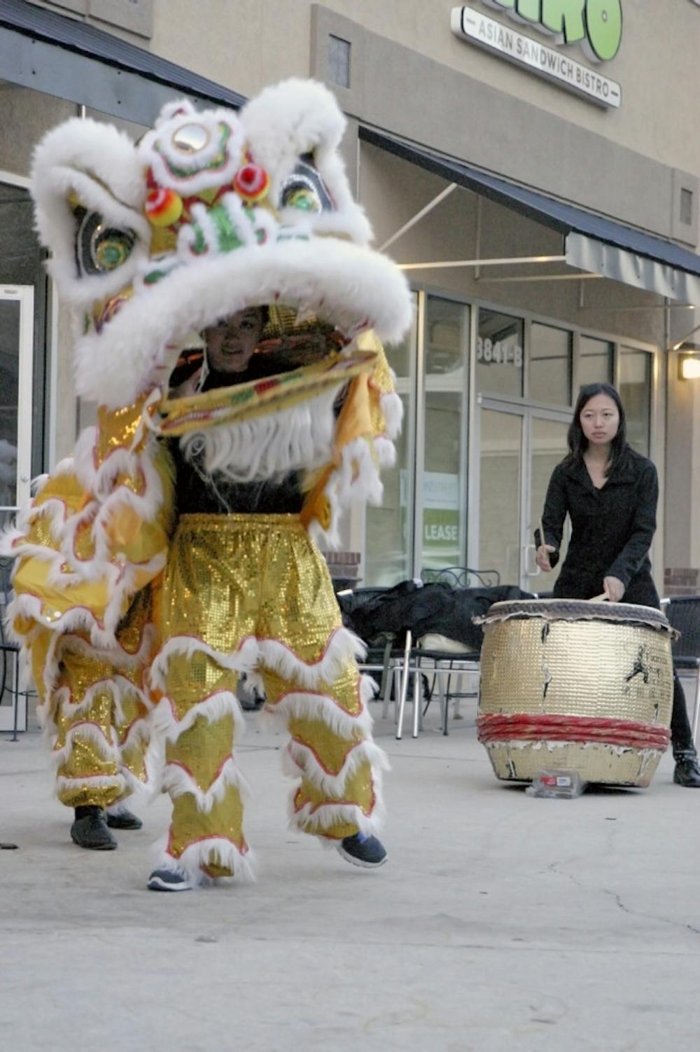 <p>Xuan Ooi, an 18-year-old UF freshman, peers through the mouth of her lion costume as she performs a lion dance to the sound of the drum outside Bento Cafe on Archer Road on Thursday. Jia-Uei Chen, also an 18-year-​old UF freshman, sets the beat for the dance, which celebrates Chinese New Year.</p><p><em>Correction: Jia-Uei Chen's name was originally misspelled.</em></p>