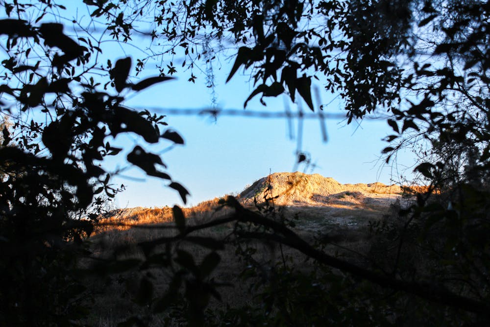 <p>The 35-foot Florence Landfill is visible beyond the barbed wire fence on Saturday, Feb. 1, 2025.</p>