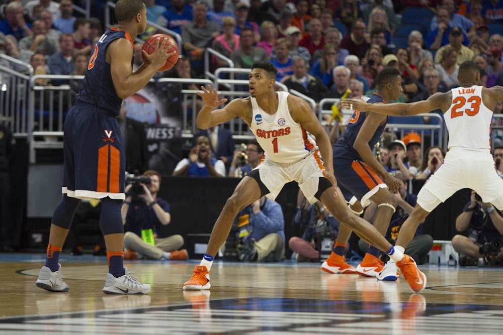 <p>UF forward Devin Robinson guards a Virginia player during Florida's 65-39 win against the Cavaliers in the NCAA Tournament on Saturday in Orlando.</p>