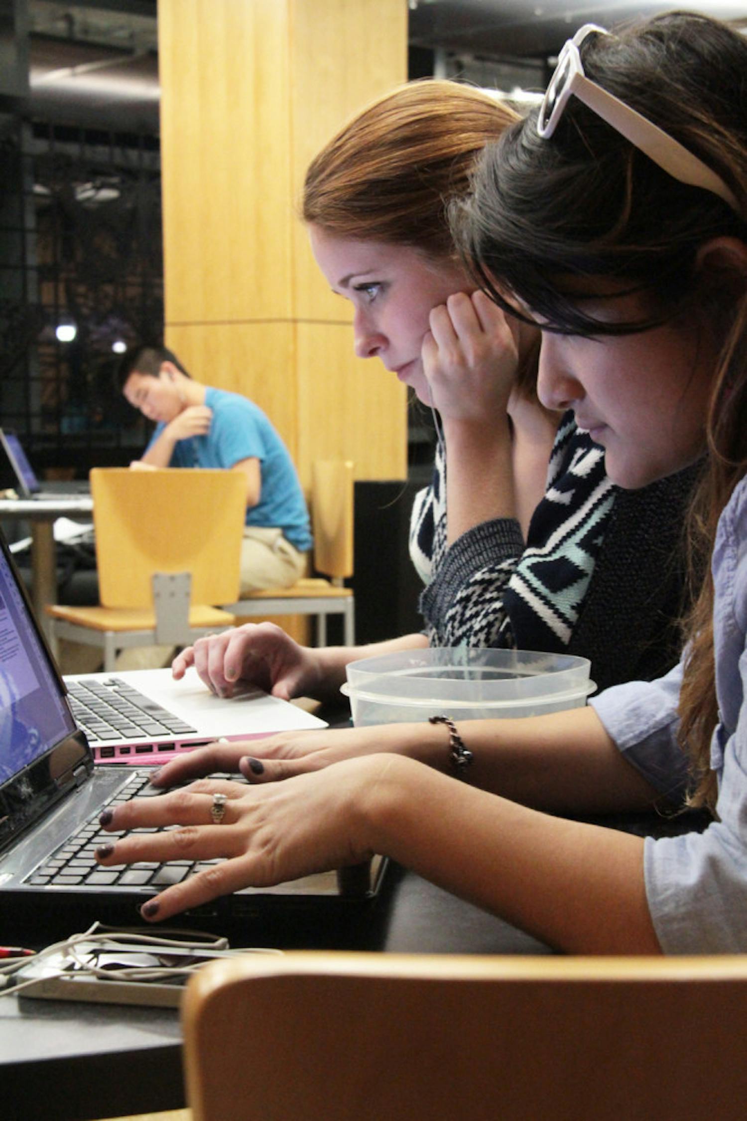 UF advertising juniors Katy Whitehurst, 20, and Ria Burgos, 20, study at Library West on Sunday night.