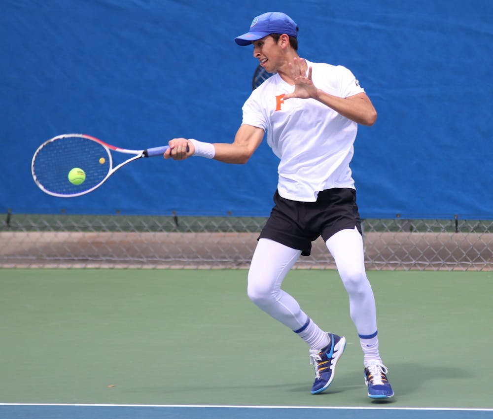 <p>Florida&#x27;s Andy Andrade returns a ball against Auburn on February 21, 2021. Andrade won his 200th career match Friday.</p>