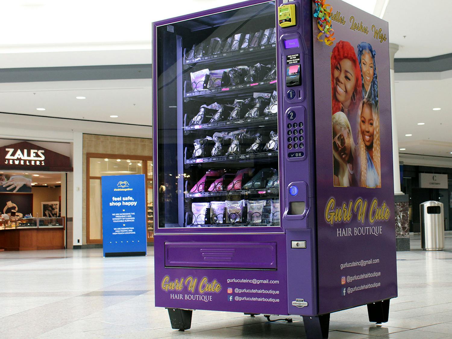 A purple vending machine owned by the Gurl U Cute Hair Boutique sits near the entrance of Oaks Mall in Gainesville on Thursday, Feb. 18, 2021. The vending machine has wig bundles and false lashes for purchase.