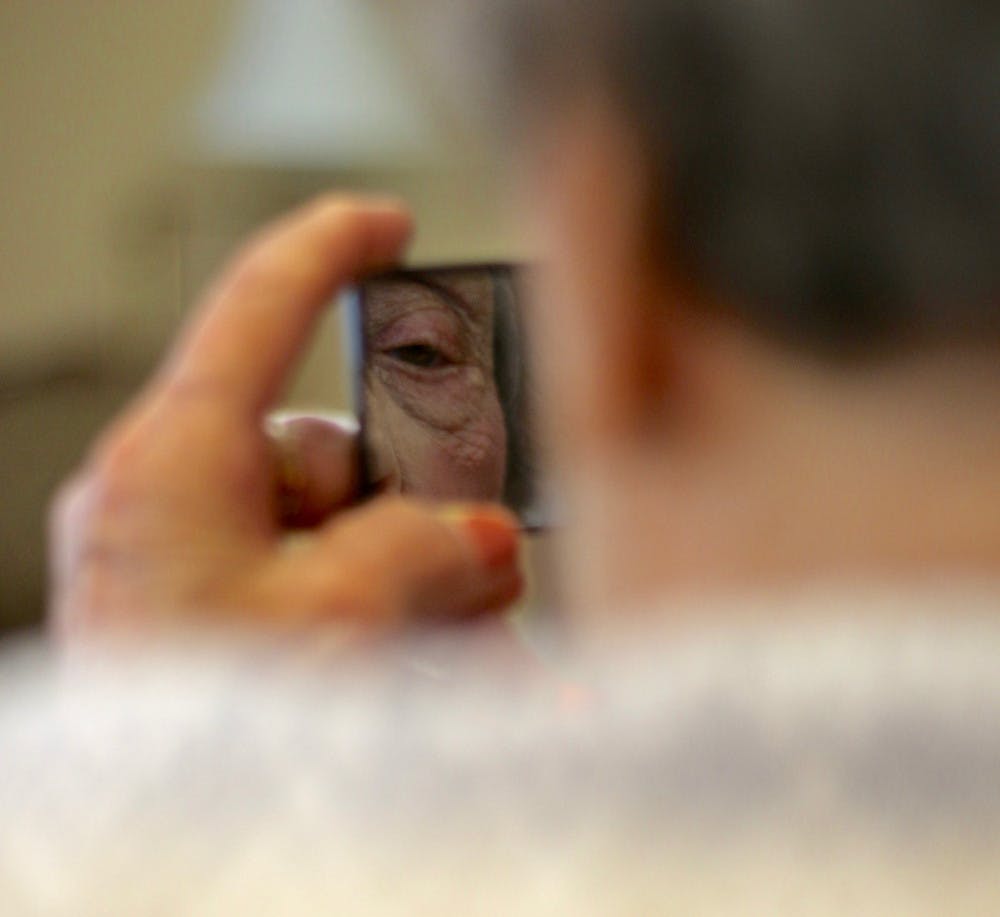 Jasmine Pointe resident Estelle Blakely, 92, admires her made-up face after receiving a makeover from GlamourGals chapter founder Allison Wrieden on Tuesday.