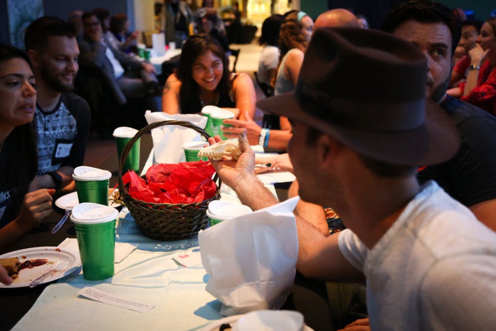 Chris Castellanos, a 22-year-old UF recreation, parks and tourism alumnus, holds an artificial fossil to find what animal it belongs to with his friends during a game organized at the Florida Museum of Natural History's Hackology on Wednesday night. About 150 people attended the event.